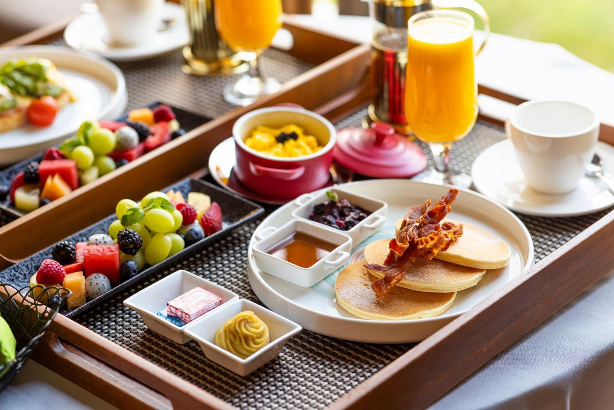 فندق Parkroyal Collection Pickering, سنغافورة المظهر الخارجي الصورة The photo shows a beautifully arranged breakfast tray. It includes:

- A stack of pancakes served with crispy bacon.
- Small bowls of syrup and fruit preserves.
- Slices of fresh fruit, including a variety of berries and grapes.
- A small dish with w